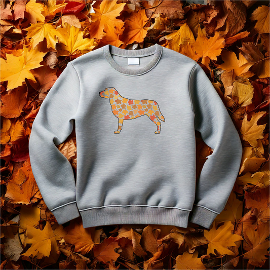 Fall-themed sweatshirt featuring a Labrador silhouette filled with autumn leaves, perfect for dog lovers and seasonal apparel. Cozy fall outfit with pet-inspired design on a soft, comfortable crewneck, surrounded by vibrant autumn leaves.