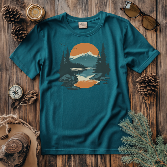 Rustic mountain and lake scene t-shirt featuring a sunset over pine trees and mountains, creating a serene outdoor vibe. Perfect for nature lovers, hikers, and those with a love for the wilderness. Ideal for casual wear, available in multiple shirt styles and colors.