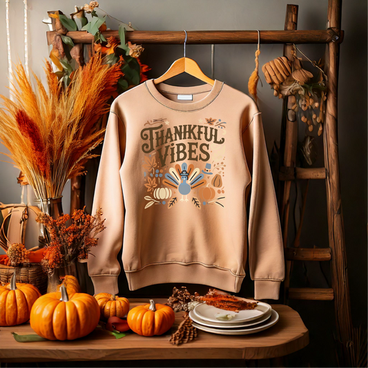 Thankful Vibes sweatshirt featuring a whimsical turkey and autumn-themed elements, perfect for Thanksgiving celebrations. Cozy fall apparel with seasonal motifs, ideal for expressing gratitude and festive spirit. Available in multiple sizes, colors, and styles.